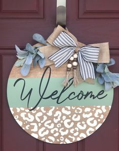 a welcome sign hanging on the front door with leopard print and blue ribbon around it