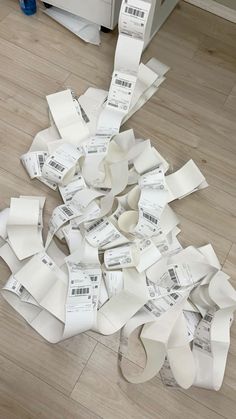 a pile of white paper sitting on top of a floor next to a wooden floor