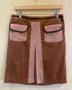 This early Ann Taylor Loft skirt features corduroy with tweedy inset and front flap pockets, velour waist and and brown piping on pockets and waistband. Side zipper.  Fully lined.  Made in Thailand. Dry clean.  Skirt Body 100% Cotton  Pockets and Insert 56% Wool 44% Rayon Lining 100% Acetate Label says size 8 Detailed Measurements: Waist - 31 inches  Hip - 38 inches  Length - 20 inches Womens Skirts, Ann Taylor Loft, Flap Pocket, Side Zipper, Ann Taylor, Mixed Media, Thailand, Womens Skirt, Zipper