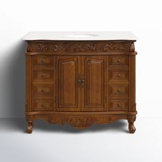 a bathroom vanity with an ornate wooden cabinet and white marble top, against a plain wall