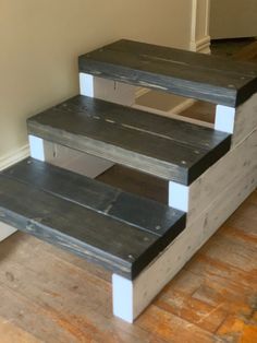 three wooden steps sitting on top of a hard wood floor