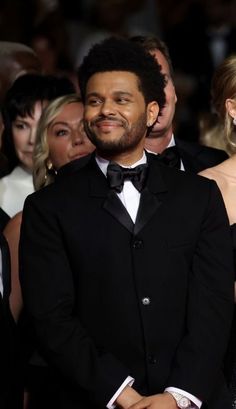 a man in a tuxedo standing next to a woman wearing a black dress