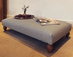 a tray with fruit on top of a striped ottoman