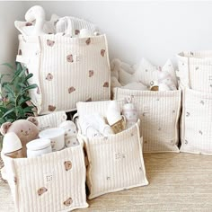 a pile of baby items sitting on top of a floor next to a potted plant