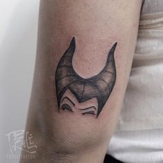 a tattoo on the arm of a person with a horned head and horns in black ink