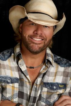 a smiling man wearing a cowboy hat