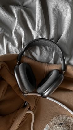 a pair of headphones sitting on top of a bed next to a white blanket