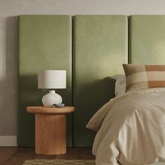 a bedroom with a bed, nightstand and green headboard