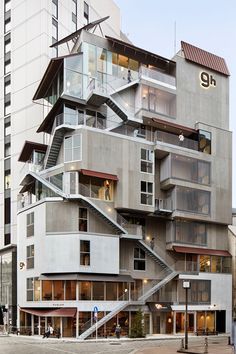 an apartment building with stairs leading up to the top floor and balconies above it