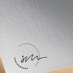 the logo for photography is displayed on a white paper with black writing and a circular design