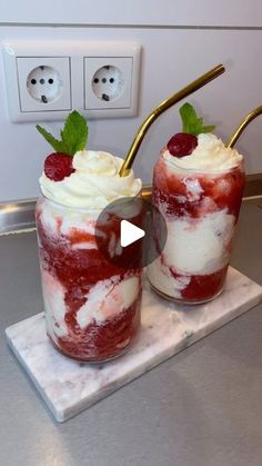 two desserts with whipped cream and raspberries in them