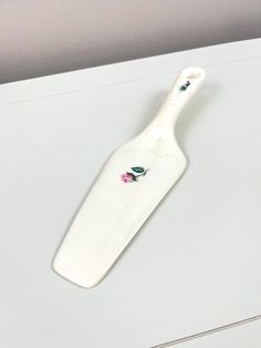 a ceramic toothbrush holder sitting on top of a white counter next to a wall