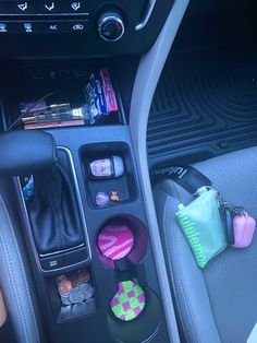 the interior of a car with various items in it's center console and cup holder