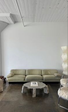 a living room with white walls and leather furniture in the center, along with a coffee table