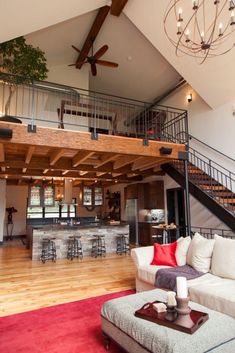 a living room filled with furniture and a fire place in front of a staircase leading up to a second story