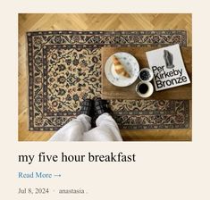 a person is sitting on the floor with their feet up in front of a coffee cup