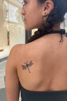 a woman with a dragonfly tattoo on her back