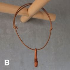 a wooden stick with a leather cord hanging from it's end on a wall