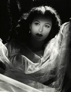 black and white photograph of a woman with her hair blowing in the wind, wearing a veil