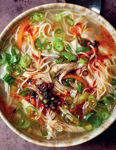 a bowl filled with noodles, meat and veggies