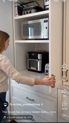 a woman is opening the door to a microwave