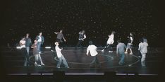 a group of people standing on top of a stage in front of a black background