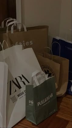 several shopping bags sitting on the floor next to each other