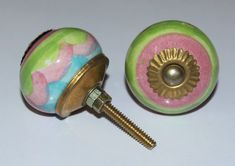 a close up of two knobs on a white surface with a screw in the middle