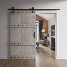 an open door in a living room with wood flooring and white walls, leading to a sitting area