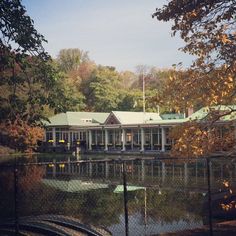 a large white house sitting on top of a lush green field next to a lake