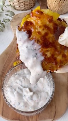 a person dipping sauce on some food in a glass bowl