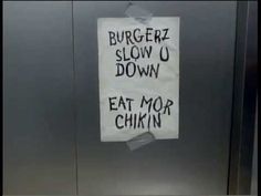 a sign that is on the side of a metal door saying burgerz slow u down eat mor chinin