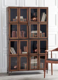 a wooden chair sitting next to a book shelf filled with books