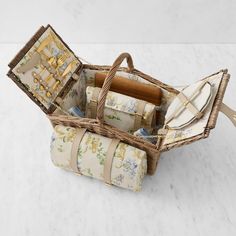 a wicker basket filled with different types of wrapping paper and other items sitting on a table