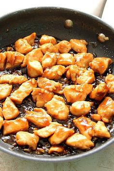 a pan filled with chicken and sauce on top of a table