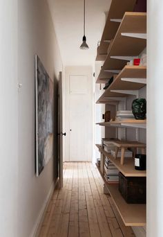 an empty hallway with shelves and wooden floors