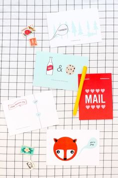 various stationery items are laid out on a gridded table top, including envelopes and stickers