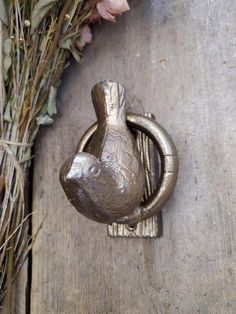 a close up of a door handle with flowers in the background