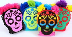 colorful sugar skull decorations are lined up on a white surface with flowers in the middle