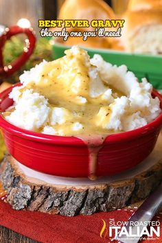 a red bowl filled with mashed potatoes covered in gravy