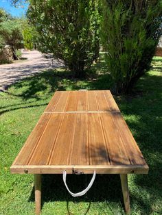 a wooden picnic table sitting in the grass