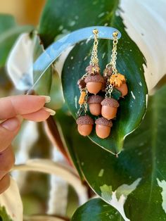 a pair of earrings with acorns hanging from them