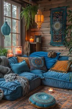 a living room filled with lots of blue furniture and pillows on top of a rug