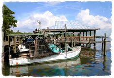 there is a boat that is docked at the water's edge with a dock in the background