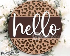 a leopard print with the word hello on it in white and brown lettering, surrounded by flowers