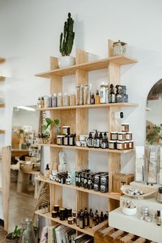 the inside of a store with shelves full of products and plants on it's sides