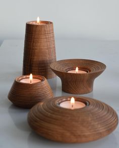 three wooden bowls with lit candles in them