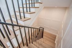 there is a set of stairs in the house with wood flooring and metal handrails