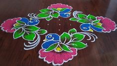 a wooden table topped with flowers and leaves on top of it's surface covered in colored paint