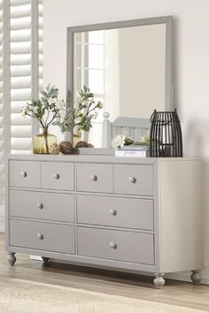 a white dresser and mirror in a room